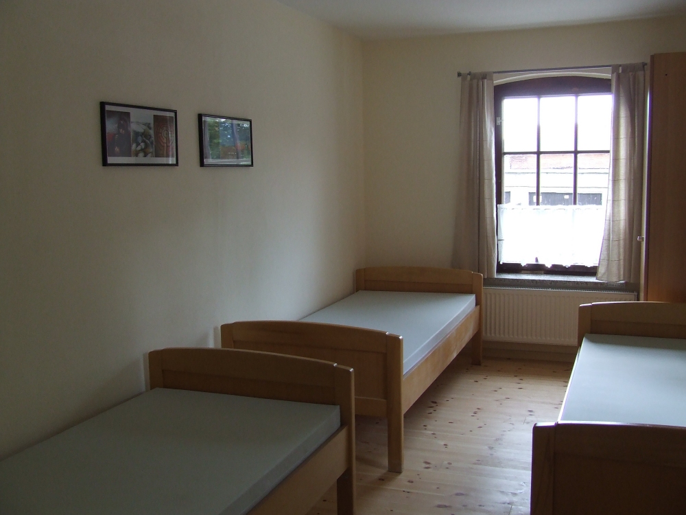 Ein Raum mit drei Betten.